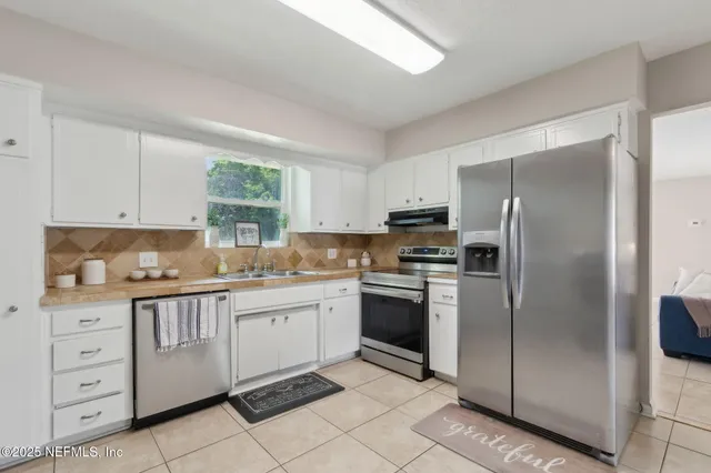 a kitchen with stainless steel appliances granite countertop a refrigerator and a stove top oven