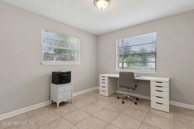 a work room with furniture a lamp and a window