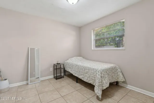 a bed sitting in a bedroom next to a window