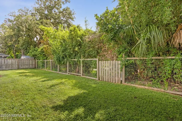a view of a yard with a wooden fence