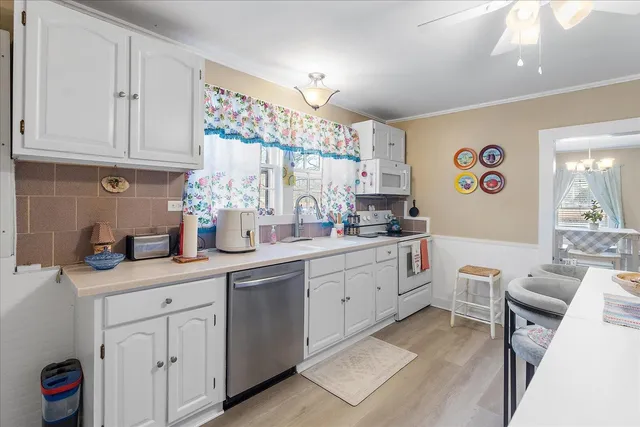 a kitchen with a refrigerator a stove a dining table and chairs with wooden floor