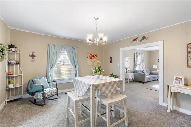 a view of a dining room with furniture and a chandelier