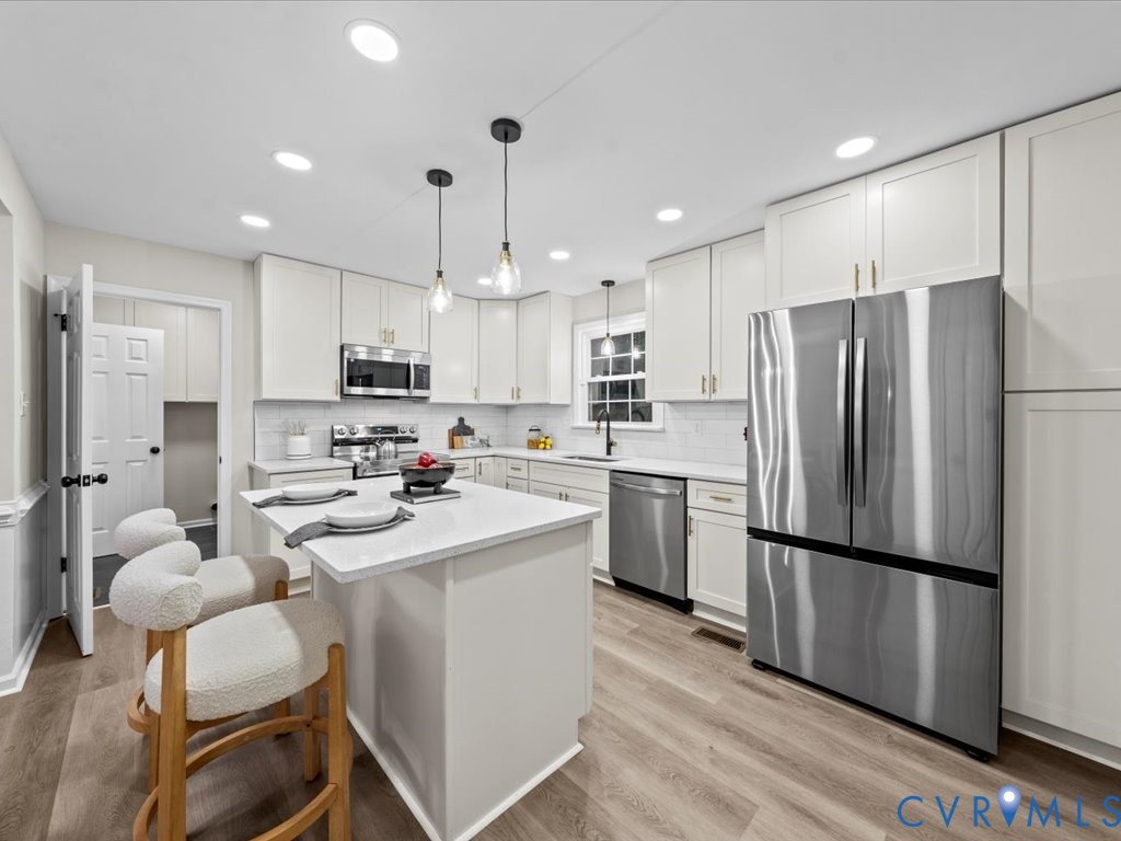 12130 Quito Road Midlothian, VA 23112 - Photo 10 of 41 a kitchen with kitchen island white cabinets and stainless steel appliances