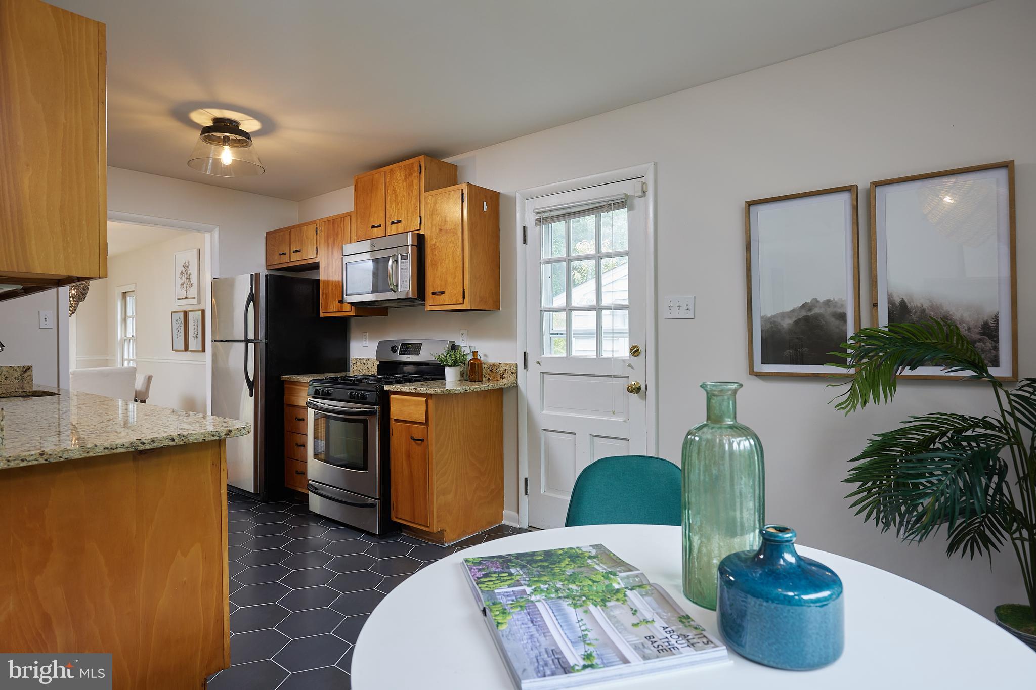 10611 Glenwild Road Silver Spring, MD 20901 - Photo 13 of 39 a kitchen with sink refrigerator dining table and chairs