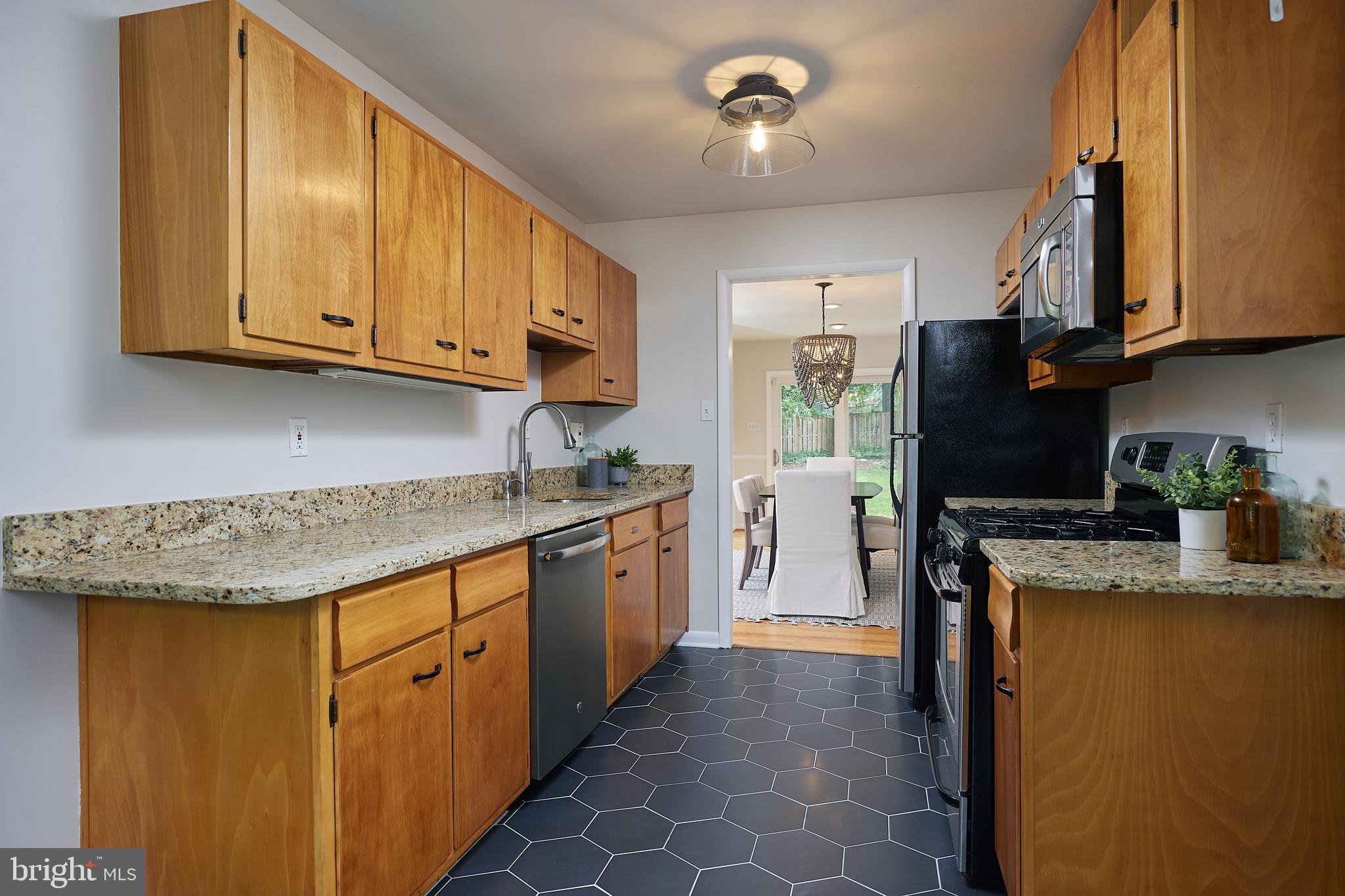 10611 Glenwild Road Silver Spring, MD 20901 - Photo 14 of 39 a kitchen with granite countertop cabinets stainless steel appliances a sink and a counter top space