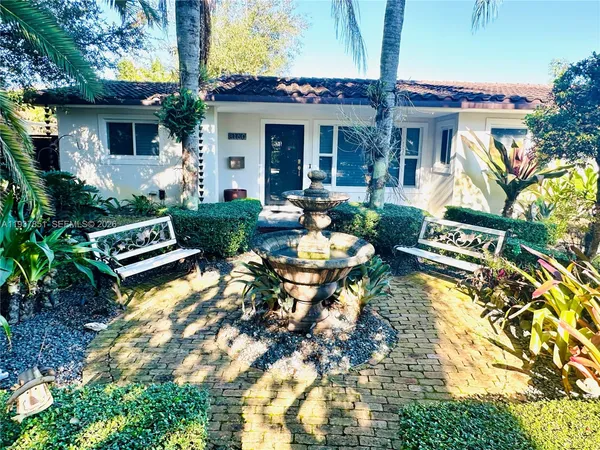 a view of a house with backyard sitting area and garden