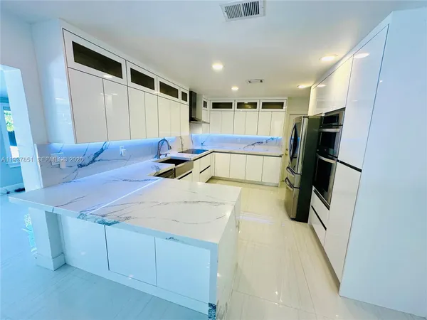 a large white kitchen with cabinets