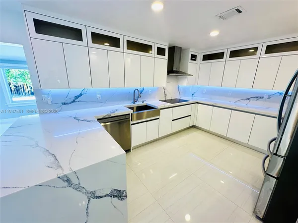 a kitchen with stainless steel appliances a refrigerator and a stove top oven