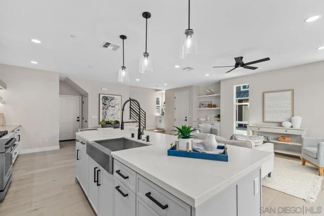 a kitchen with sink stove and living room