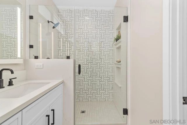 a bathroom with a shower sink and vanity