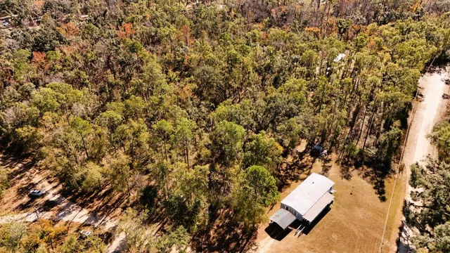 a view of sign board and trees in the background