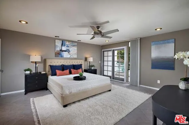 a bedroom with a large bed and a chandelier