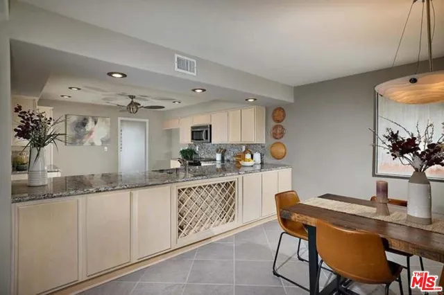 a kitchen with granite countertop white cabinets and chairs