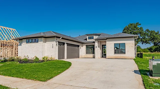 a front view of a house with a garden and plants