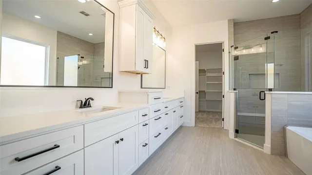 a bathroom with a double vanity sink mirror double and shower