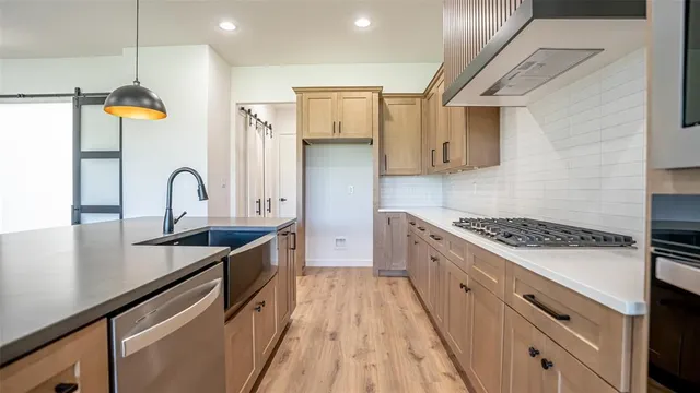a kitchen with stainless steel appliances granite countertop a sink stove and refrigerator