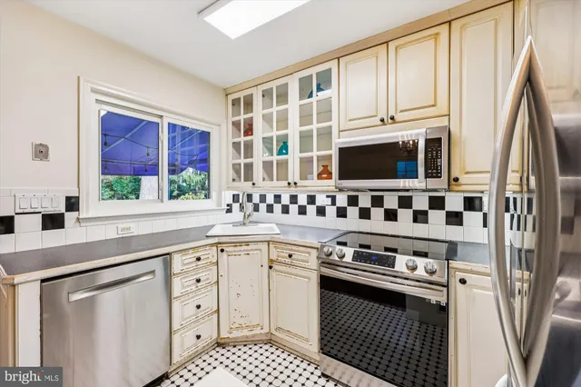 a kitchen with stainless steel appliances a refrigerator and a dining table