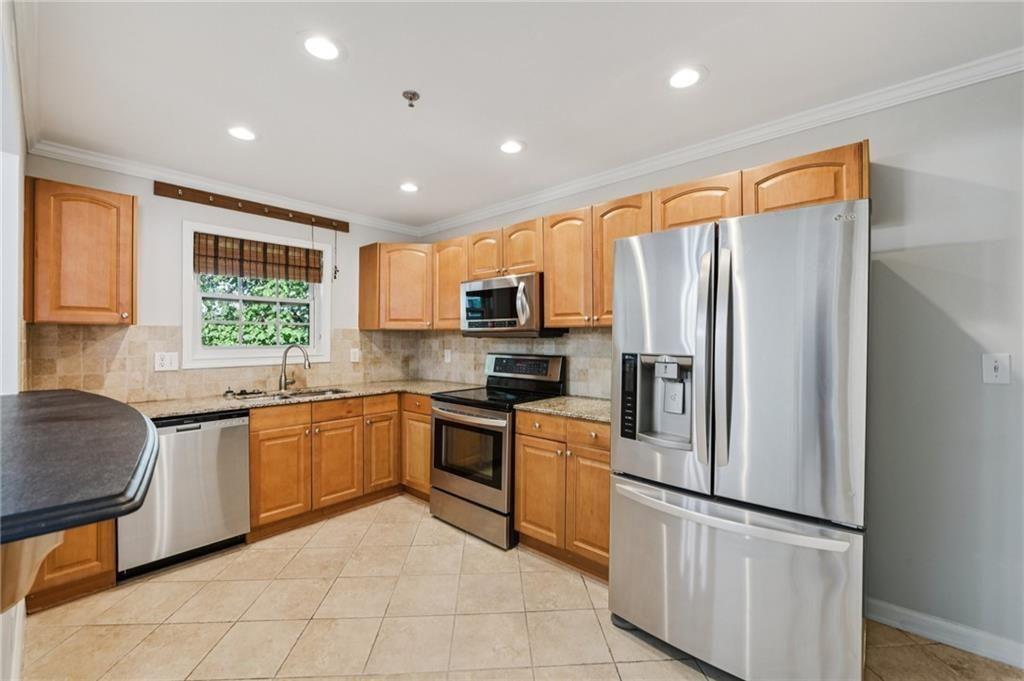 2825 Northeast Expressway, Unit F3 Atlanta, GA 30345 - Photo 19 of 45 a kitchen with granite countertop stainless steel appliances a refrigerator stove top oven and sink