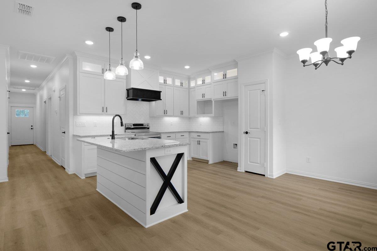 1610 West Barrett Street Tyler, TX 75702 - Photo 1 of 32 a bathroom with a sink chandelier and a view of kitchen