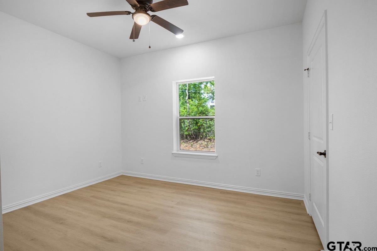 1610 West Barrett Street Tyler, TX 75702 - Photo 14 of 32 wooden floor in an empty room with a window