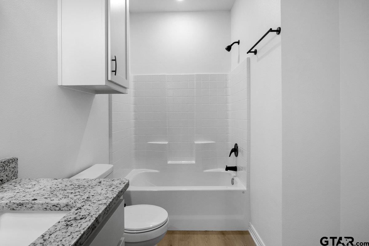 1610 West Barrett Street Tyler, TX 75702 - Photo 17 of 32 a bathroom with a granite countertop sink toilet and shower