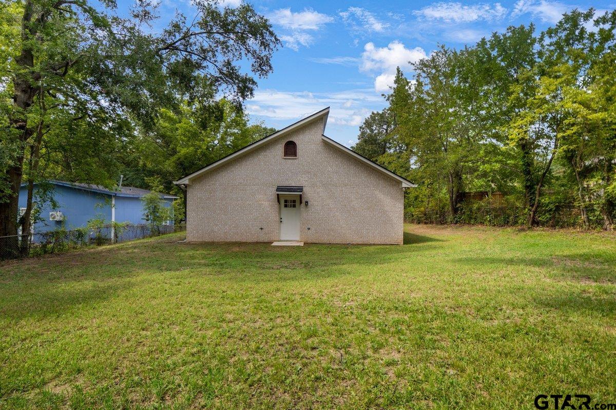 1610 West Barrett Street Tyler, TX 75702 - Photo 26 of 32 a backyard of a house with plants and large tree