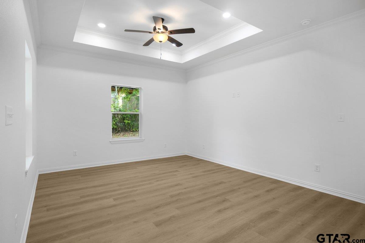 1610 West Barrett Street Tyler, TX 75702 - Photo 9 of 32 an empty room with a window and a fan