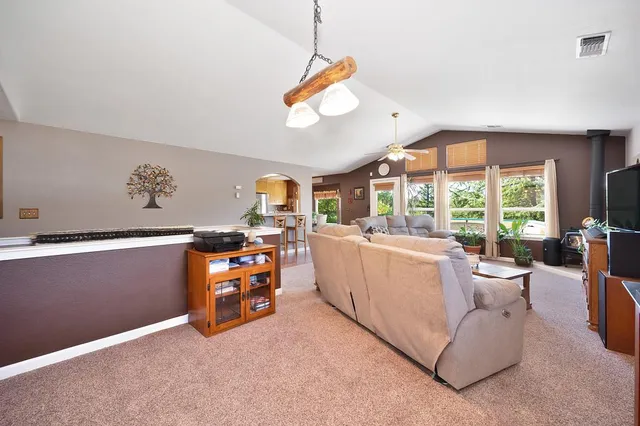 a view of a dining room with furniture large windows a chandelier and wooden floor