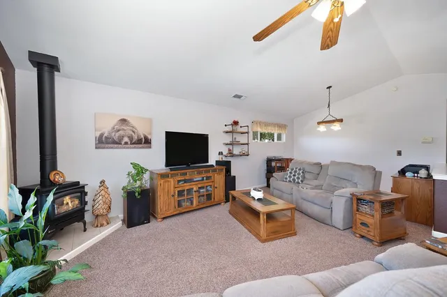 a kitchen with stainless steel appliances granite countertop a stove top oven a sink dishwasher and white cabinets with wooden floor