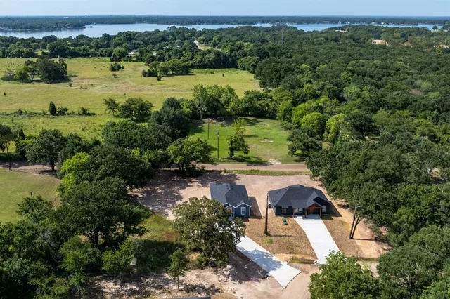 an aerial view of a house with a yard and lake view