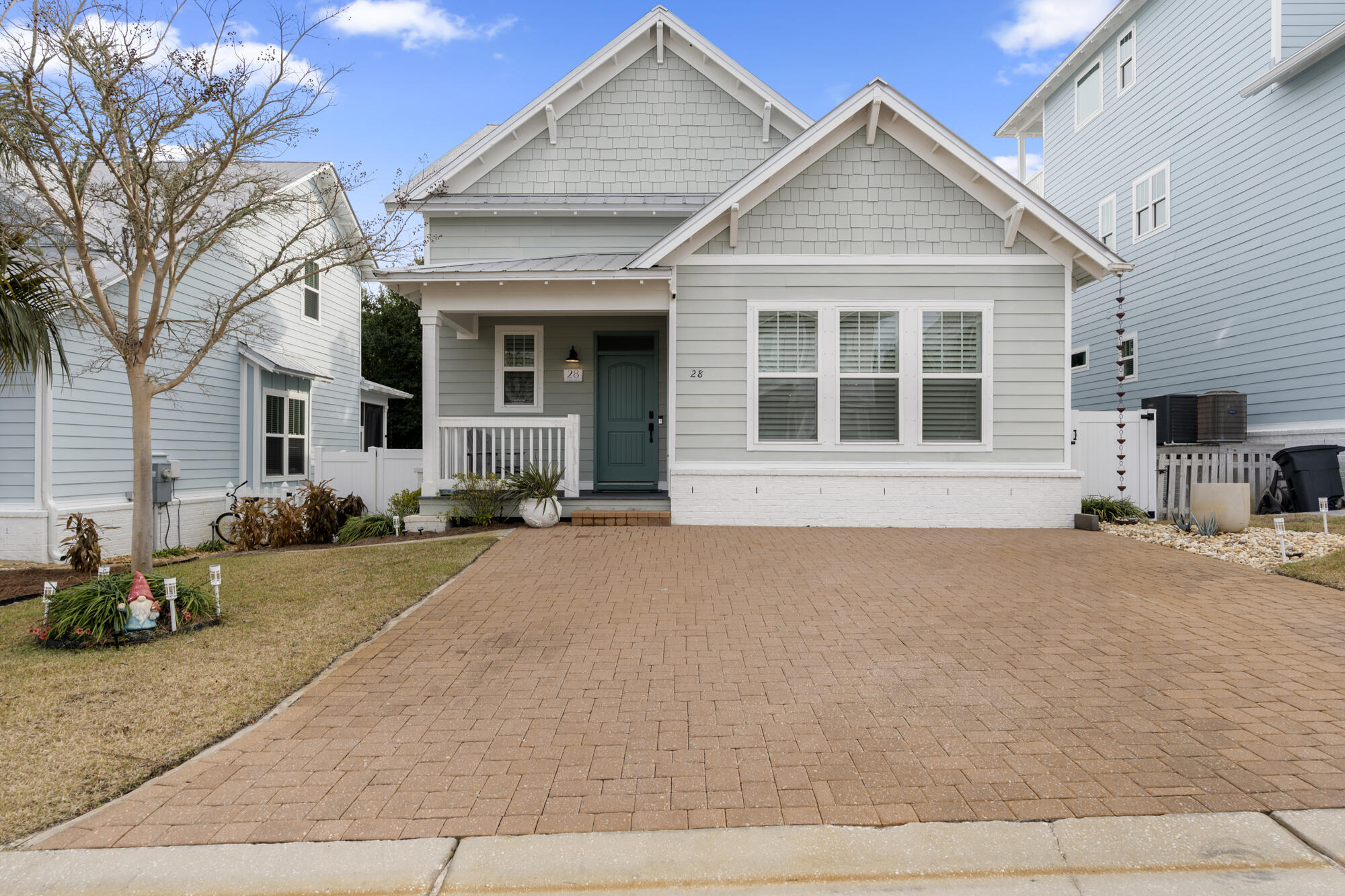 a front view of a house with a yard and potted plants