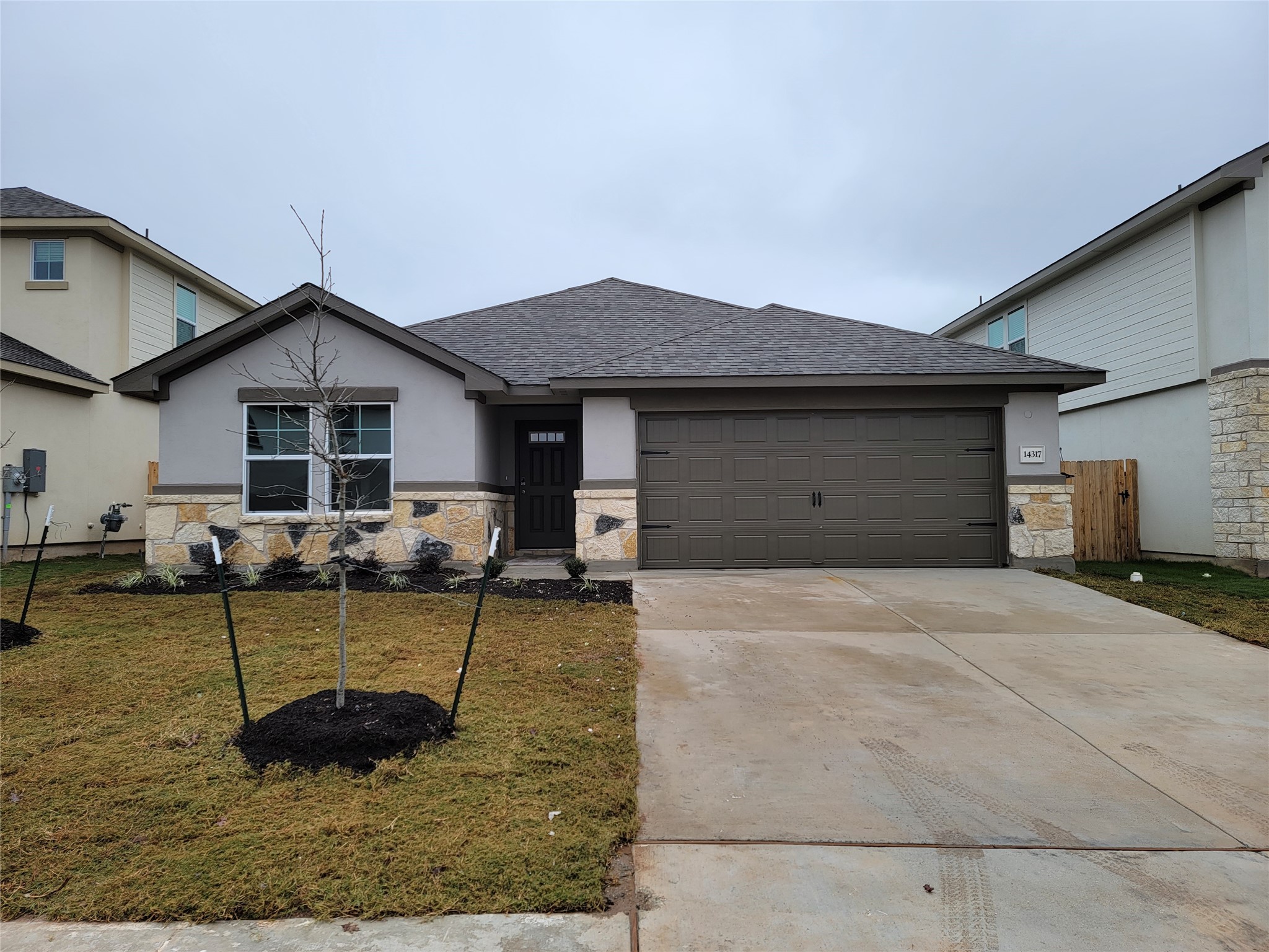14317 Bryce Lane Manor, TX 78653 - Photo 1 of 26 a front view of a house with garden