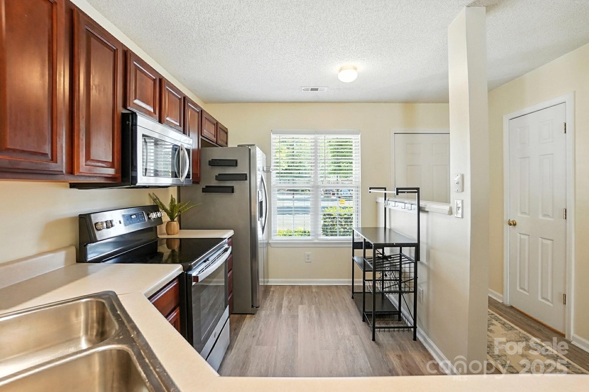 8130 Rudolph Road Charlotte, NC 28216 - Photo 11 of 36 a kitchen with stainless steel appliances granite countertop a refrigerator and a sink