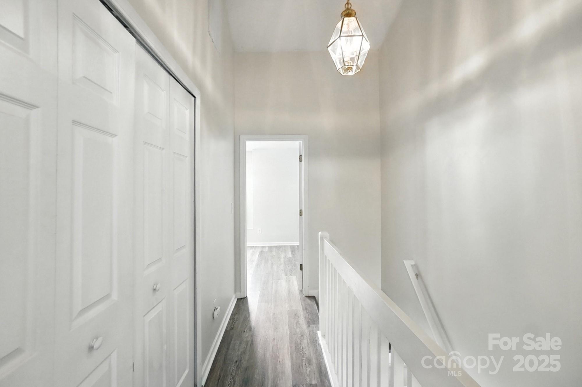 8130 Rudolph Road Charlotte, NC 28216 - Photo 16 of 36 a view of a hallway with wooden floor and staircase