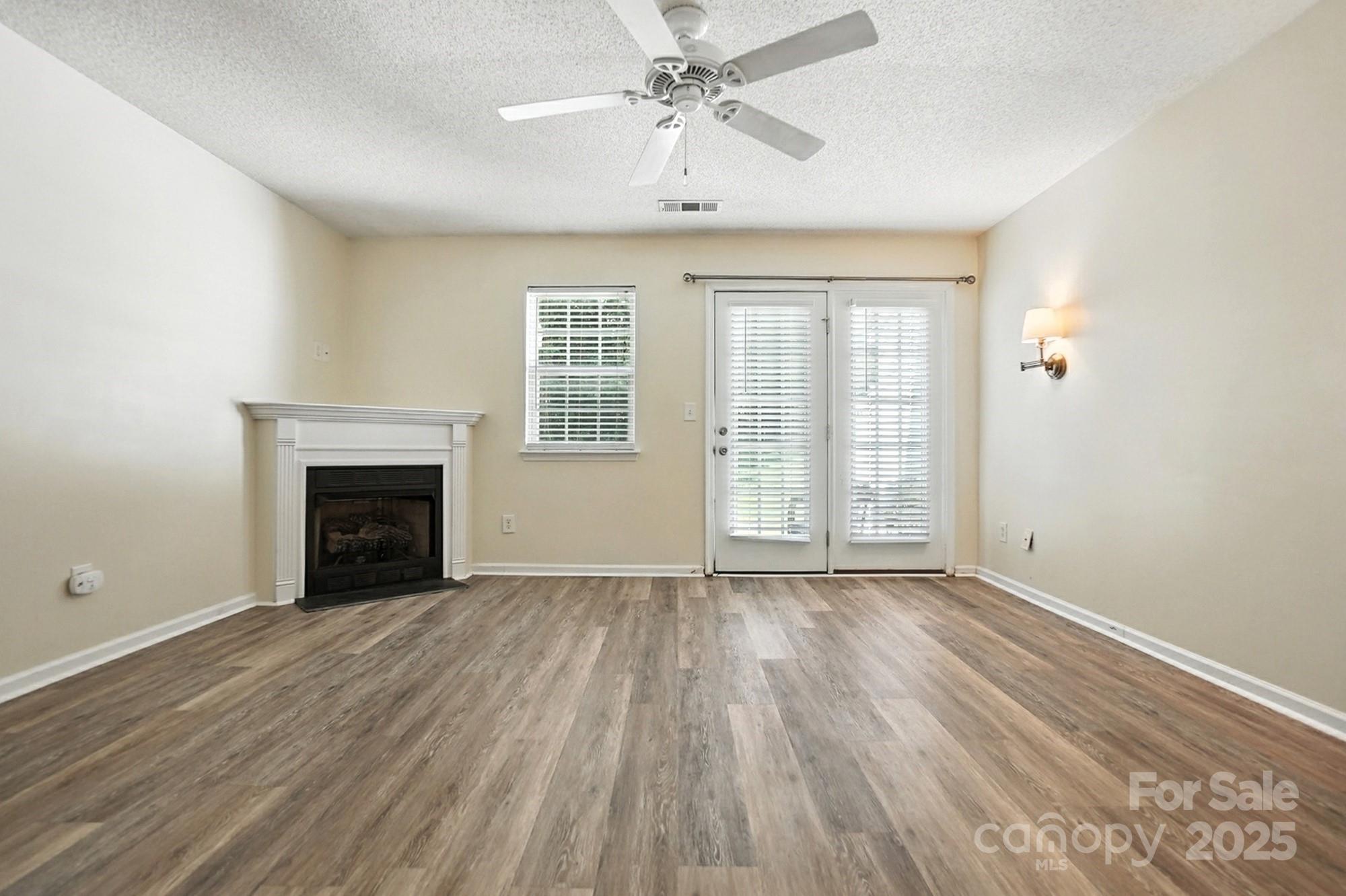 8130 Rudolph Road Charlotte, NC 28216 - Photo 30 of 36 wooden floor fireplace and windows in an empty room