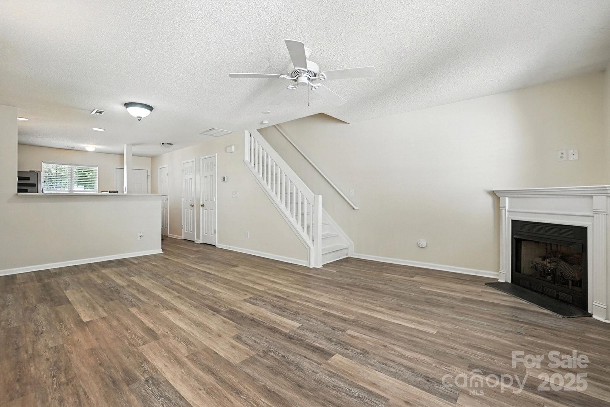 8130 Rudolph Road Charlotte, NC 28216 - Photo 31 of 36 a view of an empty room with wooden floor fireplace and a window