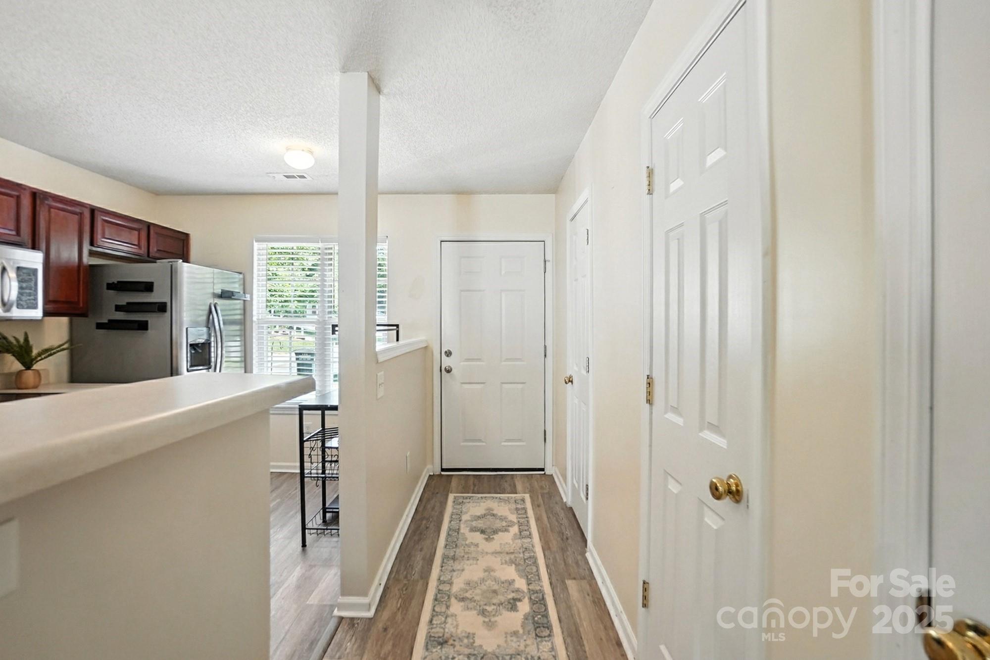 8130 Rudolph Road Charlotte, NC 28216 - Photo 4 of 36 a view of a hallway with closet and wooden floor