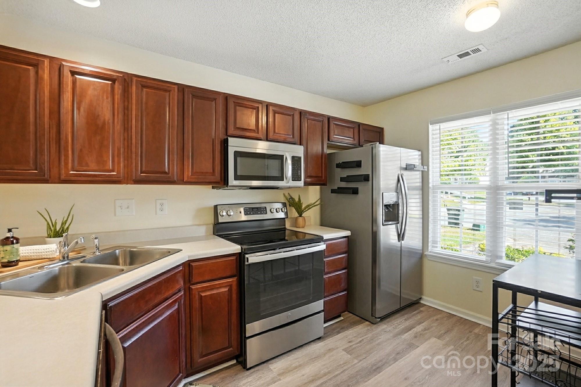 8130 Rudolph Road Charlotte, NC 28216 - Photo 8 of 36 a kitchen with stainless steel appliances granite countertop a refrigerator microwave and sink