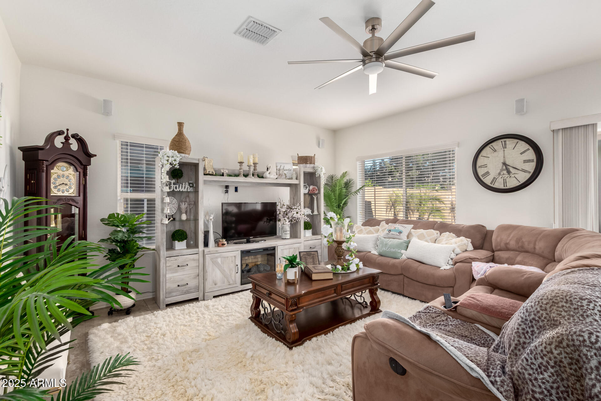 2665 East Gillcrest Road Gilbert, AZ 85298 - Photo 9 of 48 a living room with furniture a clock and a flat screen tv