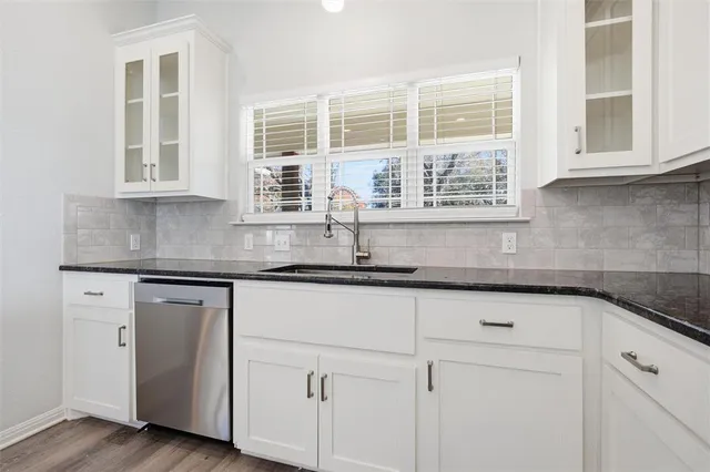 a kitchen with stainless steel appliances granite countertop white cabinets and a granite counter tops