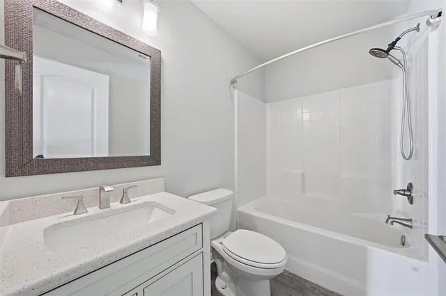 a bathroom with a sink toilet vanity and shower
