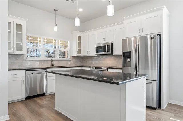 a kitchen with stainless steel appliances granite countertop a refrigerator and a sink