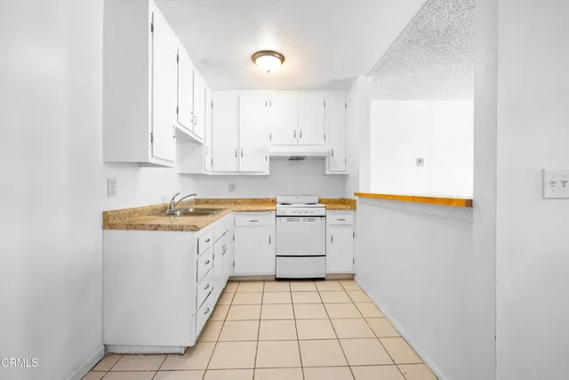 a kitchen with white cabinets appliances and a sink