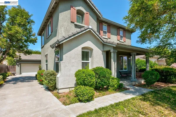 a front view of a house with a garden and yard