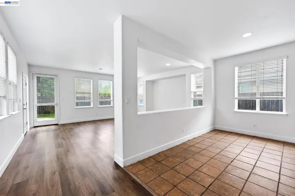 a kitchen with granite countertop a stove top oven a sink dishwasher a refrigerator and white cabinets with wooden floor