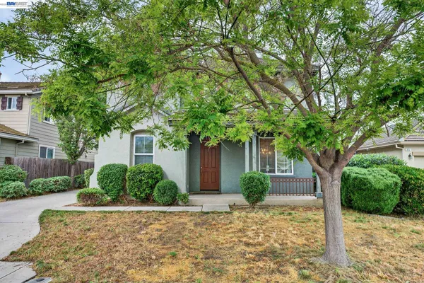 an empty room with wooden floor chandelier and windows