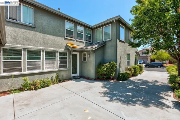 a dining room with wooden floor a chandelier a wooden table and chairs