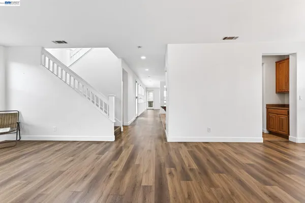 a view of a livingroom with wooden floor and staircase