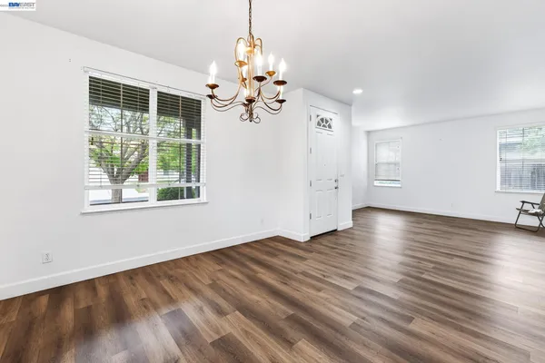 a view of empty room with wooden floor and windows