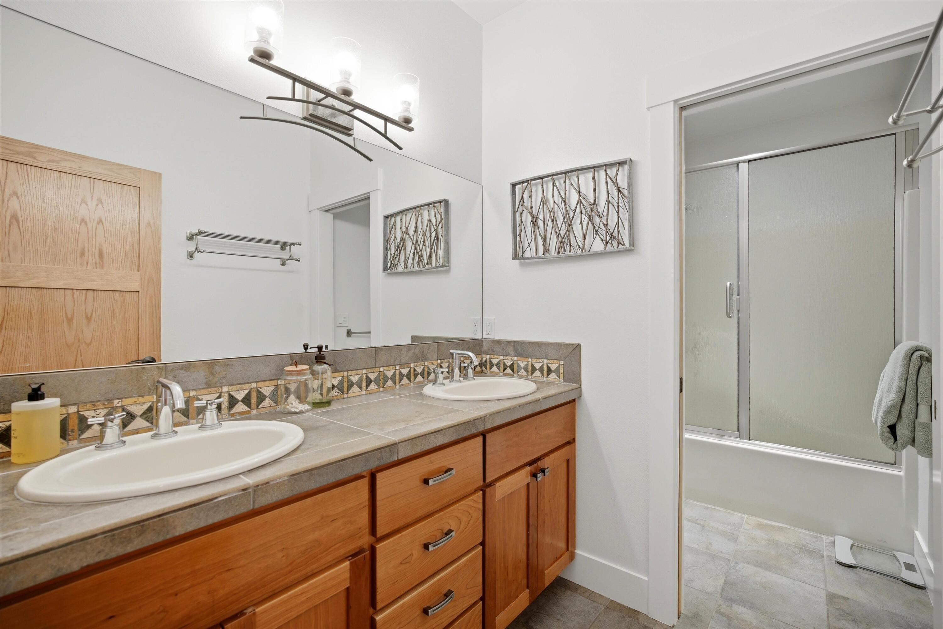 15 Southwest Quail Butte Place Bend, OR 97703 - Photo 41 of 55 a bathroom with a granite countertop sink mirror and double